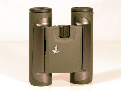 Khaki green binoculars with black highlights and a small, silver eagle.